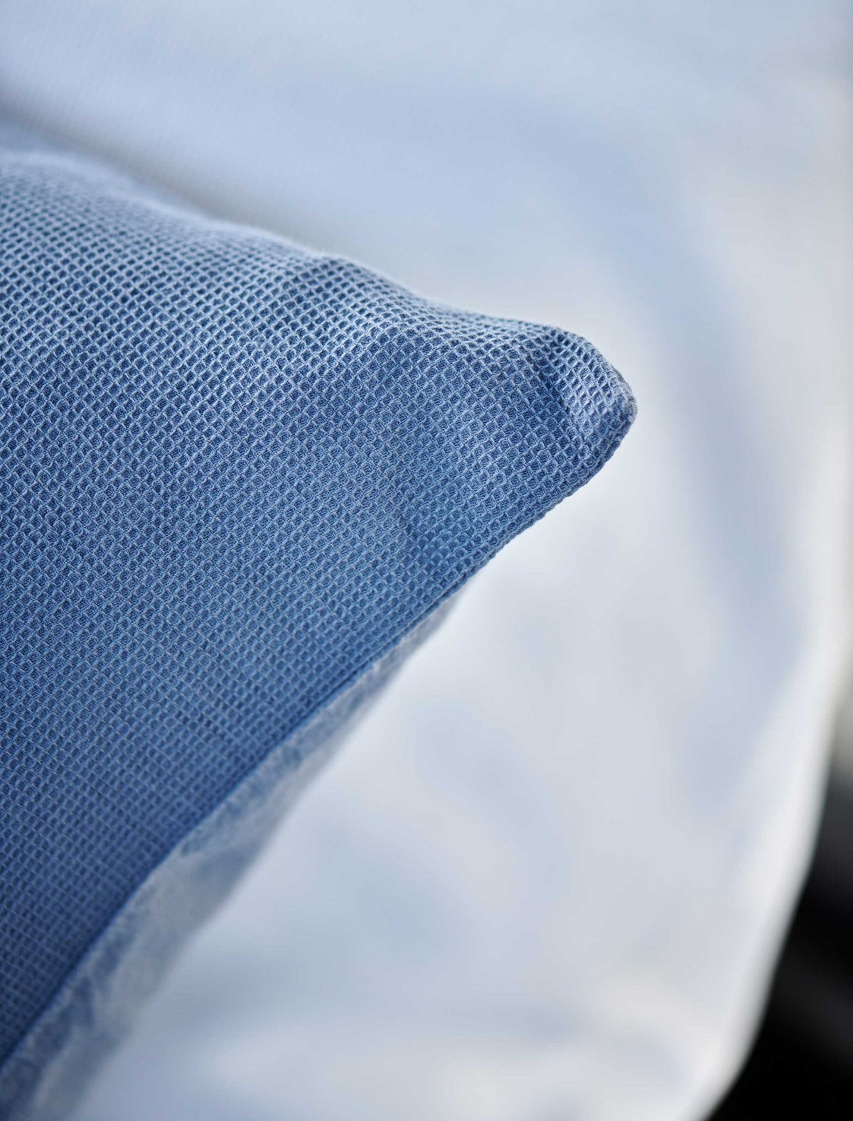 detail shot van een hoofdkussen met een wafelstructuur in een jeans blauwe kleur